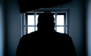 Horror, man in dark room staring out window