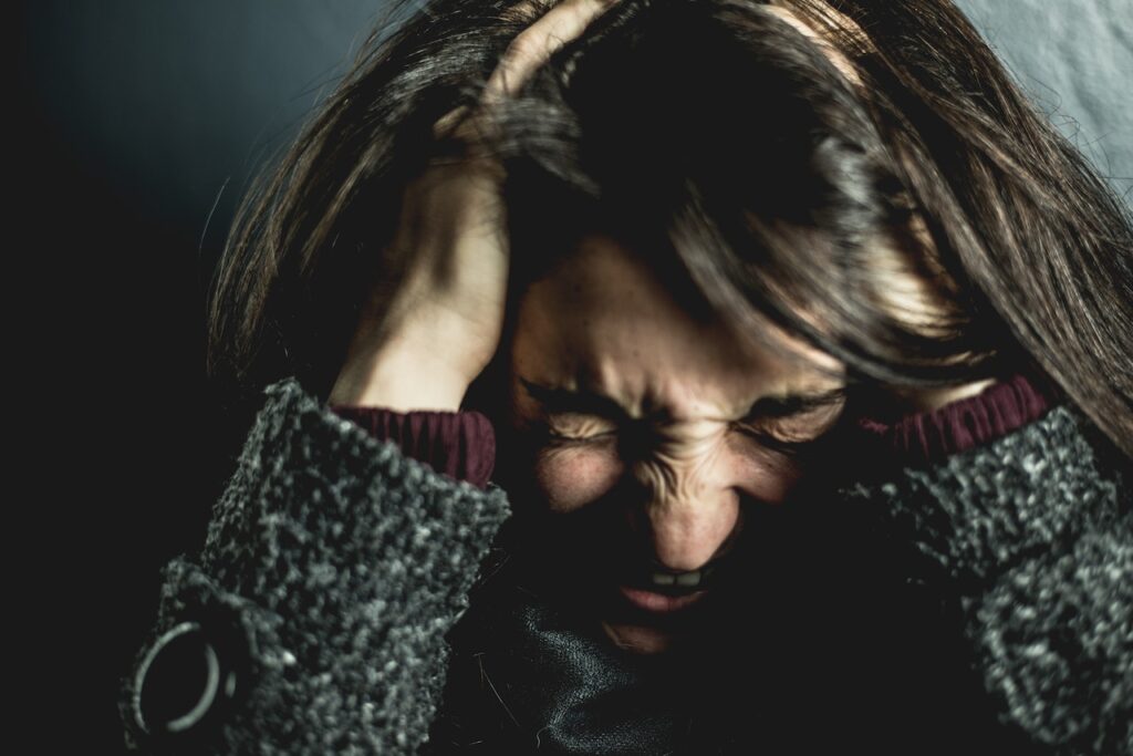woman holding head, self-sabotage, anxiety, stress